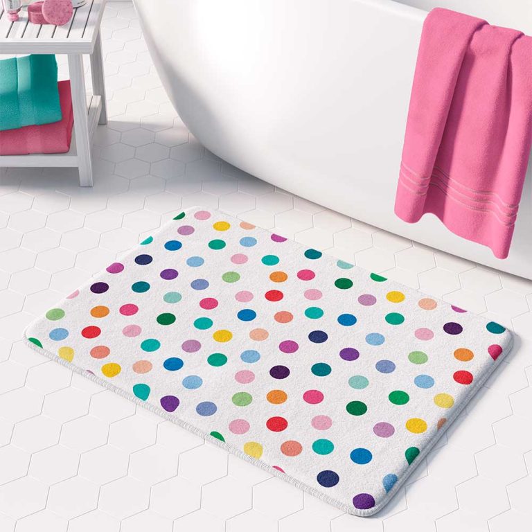 A white microfiber non slip bath mat for kids featuring a cheerful polka dot pattern in various vibrant colors. Mold and mildew resistant, plush, soft, machine washable, and quick drying.