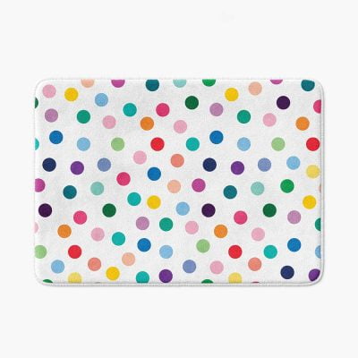 A white microfiber non slip bath mat for kids featuring a cheerful polka dot pattern in various vibrant colors. Mold and mildew resistant, plush, soft, machine washable, and quick drying.