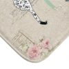 Close-up of a beige and pink rose floral design on a cat bath mat.