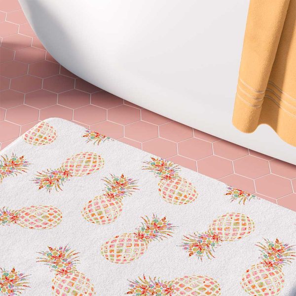 White bath mat with tropical pink and orange pineapple pattern.