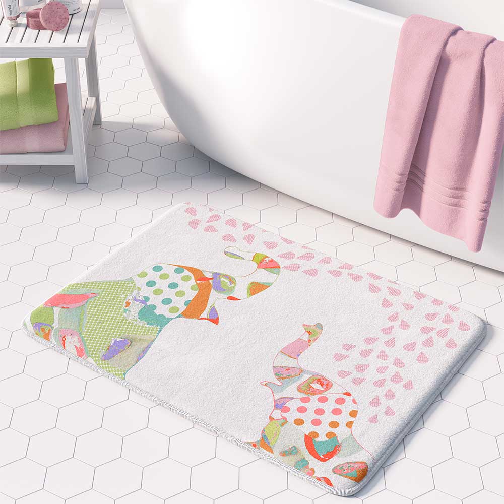 A white microfiber non slip bath mat for kids featuring a playful pink and green elephant print. Mold and mildew resistant, plush, soft, machine washable, and quick drying.