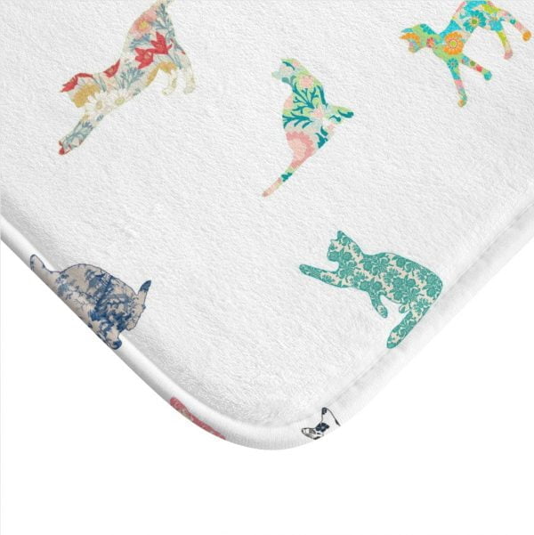 Close-up of a patchwork cat design on a white memory foam bath mat.