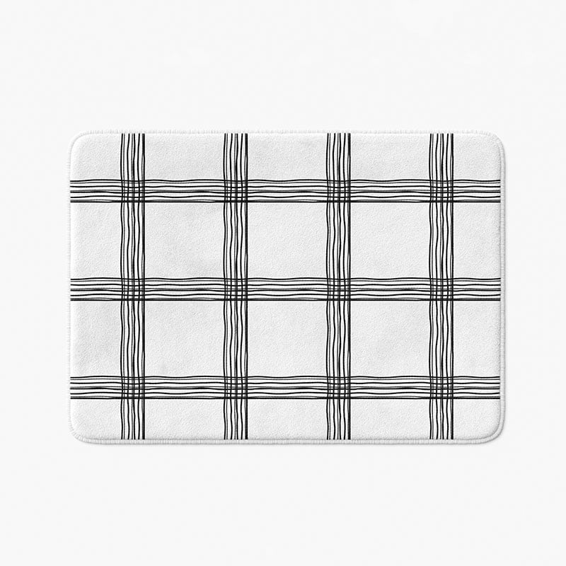 Black and white checked bath mat with artist-designed geometric pattern.