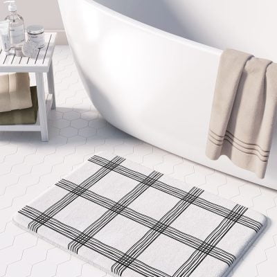 Black and white checked bath mat with artist-designed geometric pattern.
