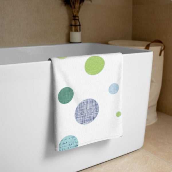 White bath towel with blue and green polka dot pattern
