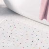 A girls' bathroom bath mat featuring tiny colorful polka dots
