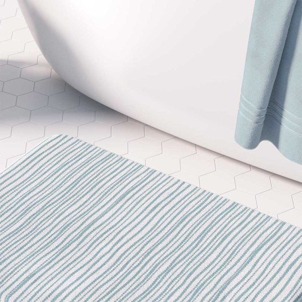 A coastal blue striped bath mat perfect for a small bathroom, master, or guest bathroom. Mold and mildew resistant, quick-drying, non-slip plush microfiber, washable.