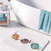 A colorful kids bath mat adorned with vibrant fish patterns, perfect for a kids' bathroom. Mold and mildew resistant, quick-drying, non-slip plush microfiber, washable.