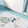 A white microfiber non slip bath mat for kids featuring a playful blue and green elephant print. Mold and mildew resistant, plush, soft, non-slip, machine washable, and quick drying.