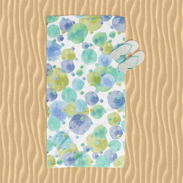 White cotton polyester velour beach towel adorned with playful blue and green watercolor polka dots.