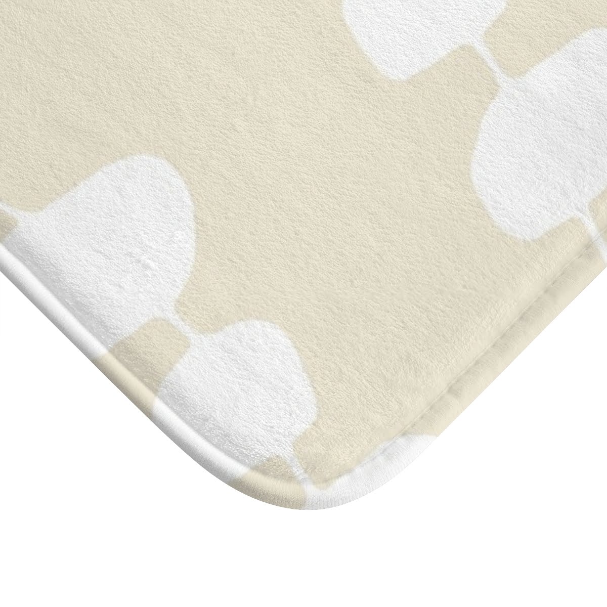 Close-up view of the microfiber texture on the coastal beige and white pebble striped designer non-slip bath mat.