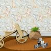 Dinosaur wallpaper in modern contemporary design with orange, gray, blue, mustard, and white colors in a kids playroom.