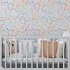 Dinosaur wallpaper in modern contemporary design with orange, gray, blue, mustard, and white colors in a baby nursery.
