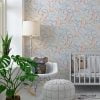 Dinosaur wallpaper in modern contemporary design with orange, gray, blue, mustard, and white colors in a baby nursery.