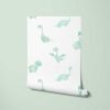 Detailed view of a mint green dinosaur wallpaper roll, available in vinyl, paper, or fabric peel and stick options