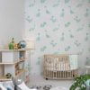 Mint green dinosaur wallpaper in a baby nursery, available in vinyl, paper, or fabric peel and stick options