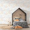 Dinosaur wallpaper in modern contemporary design with orange, gray, blue, mustard, and white colors in a kids bedroom.