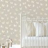Modern kids’ room with Boho Butterfly Beige Wallpaper, rattan furniture, and neutral boho decor.